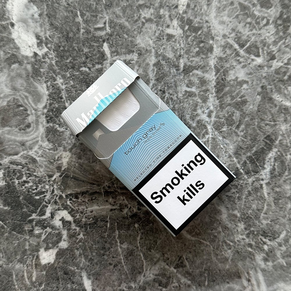 Cigarette cases UK shown beside a lighter and premium Marlboro pack
